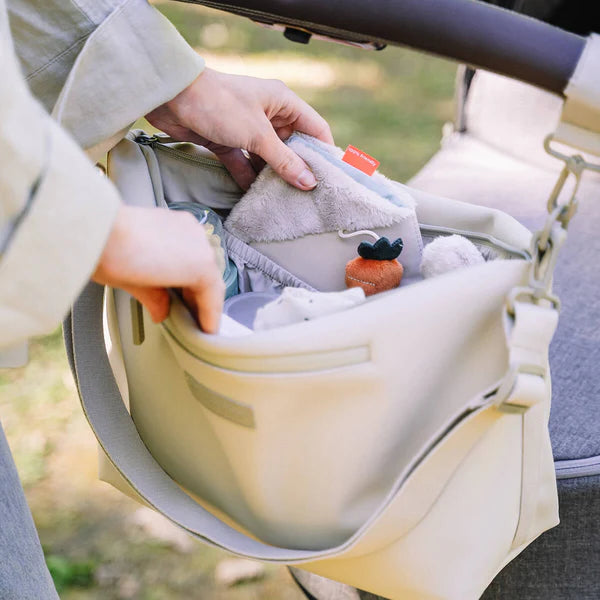 Organizador para carrito de bebé en beige, práctico y espacioso.