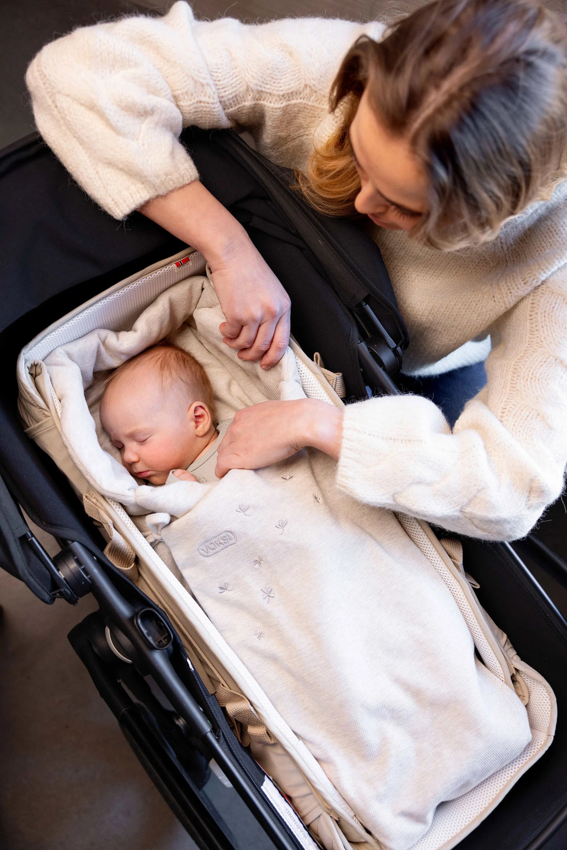 Saco Voksi Wool Wrap arena colocado en capazo de carrito